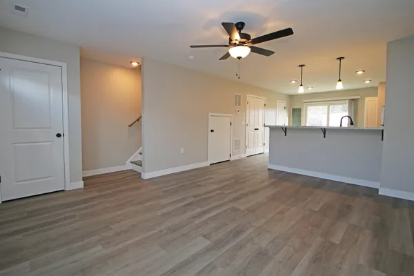 an empty room with wooden floor and a ceiling fan
