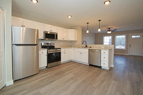 a kitchen with a refrigerator a sink and cabinets