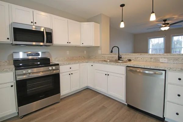 a view with cabinets stainless steel appliances and wooden floor