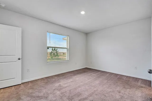 a bedroom with a large bed and a potted plant