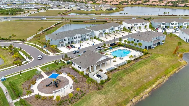 a front view of multi story residential apartment building with yard and bench