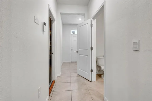 a white toilet sitting next to a white marble wall