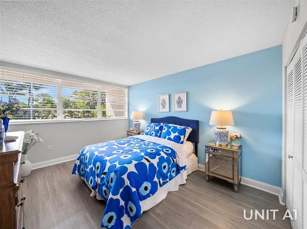 a bedroom with a large bed and a lamp on table