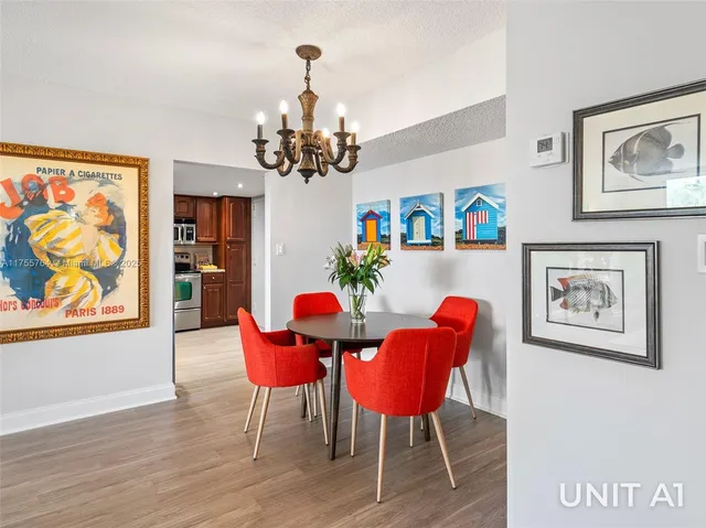 a view of a dining room with furniture a chandelier and wooden floor