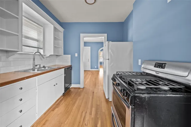a kitchen with a stove and white cabinets