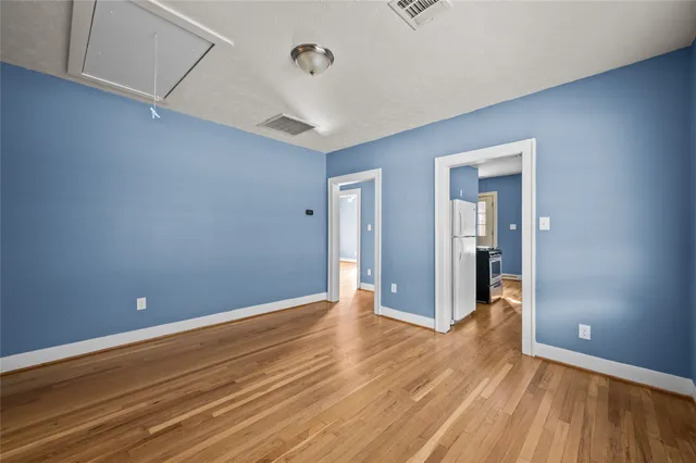 a view of an empty room with wooden floor