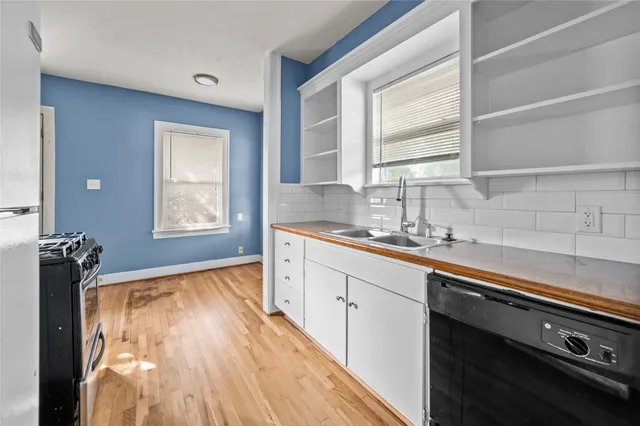 a kitchen with a sink wooden floor and a large window
