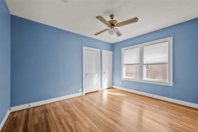 a view of a big room with wooden floor and windows