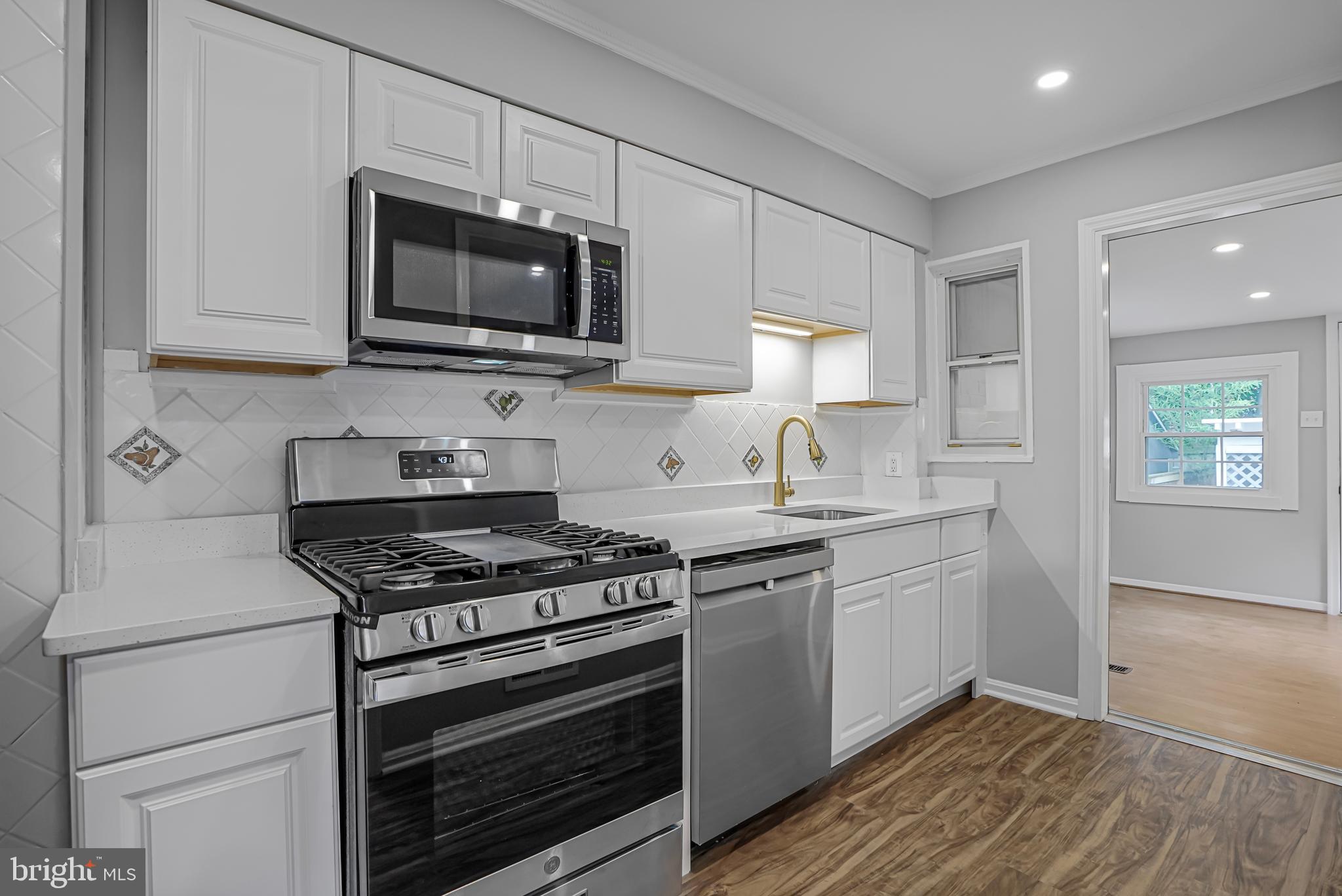 3202 13th Road South Arlington, VA 22204 - Photo 3 of 32 a kitchen with stainless steel appliances a stove a microwave and sink