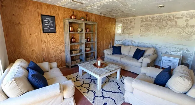 a living room with furniture and painting on the wall