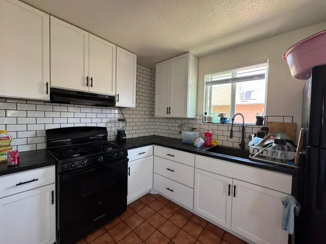 a kitchen with white cabinets and a stove