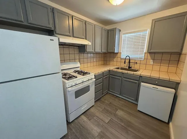 a kitchen with granite countertop a sink stainless steel appliances and cabinets
