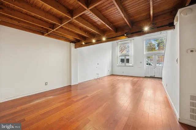 a view of empty room with wooden floor