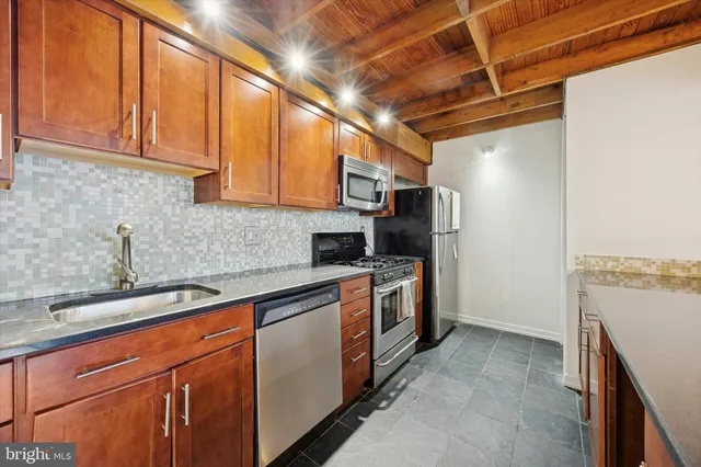 a kitchen with stainless steel appliances granite countertop a sink a stove and a refrigerator