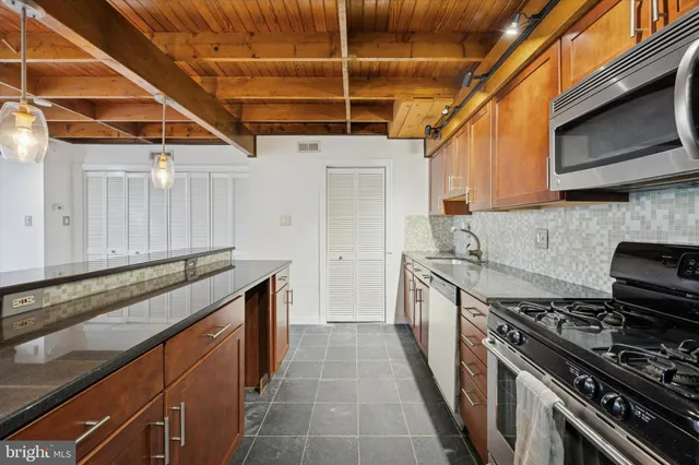 a kitchen with stainless steel appliances granite countertop a stove and a sink