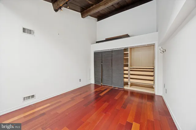 a view of empty room with wooden floor