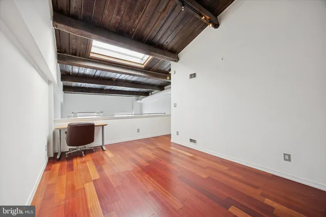 a view of an empty room with wooden floor
