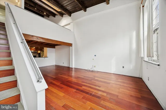 a view of a hallway with wooden floor and stairs