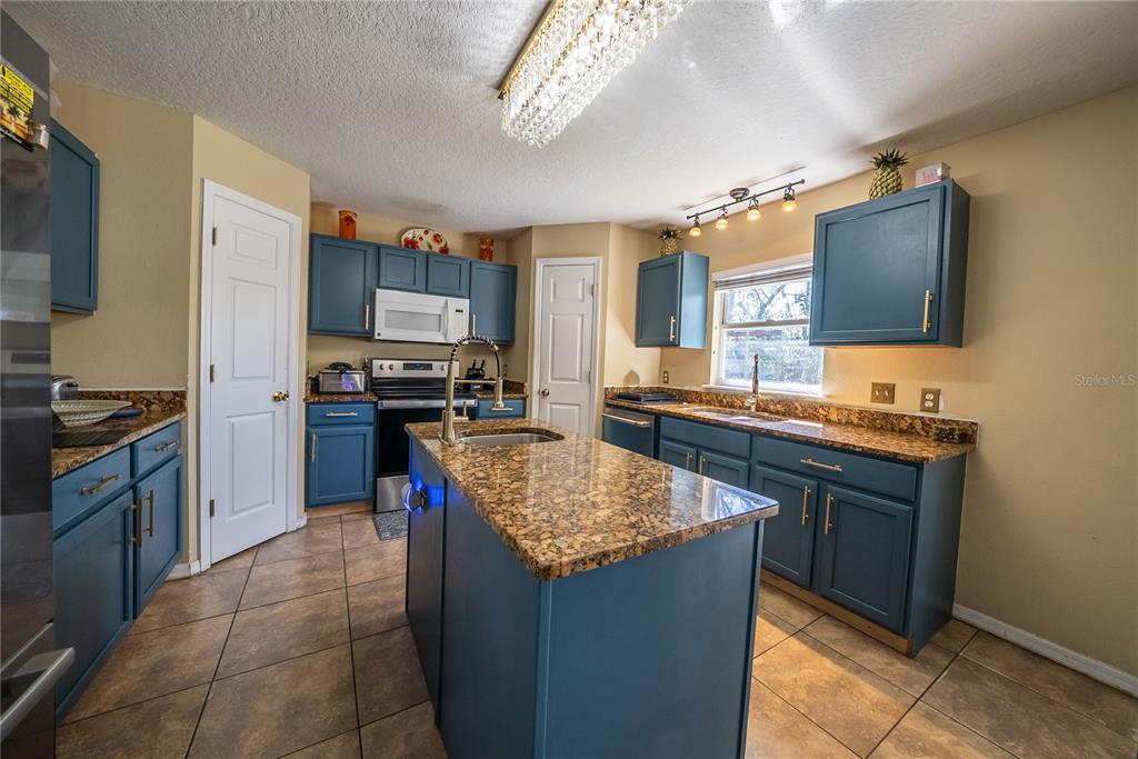 5306 Southwest 115th Street Road Ocala, FL 34476 - Photo 11 of 56 a kitchen with stainless steel appliances granite countertop a sink stove and refrigerator
