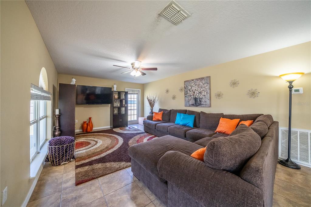 5306 Southwest 115th Street Road Ocala, FL 34476 - Photo 14 of 56 a living room with furniture and a flat screen tv