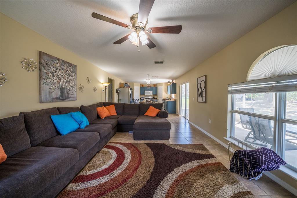 5306 Southwest 115th Street Road Ocala, FL 34476 - Photo 17 of 56 a living room with furniture ceiling fan and a window