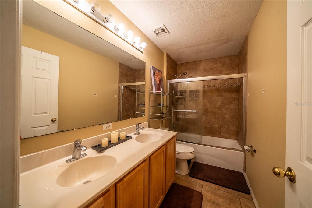 5306 Southwest 115th Street Road Ocala, FL 34476 - Photo 29 of 56 a bathroom with a sink a toilet and shower