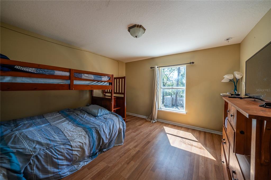 5306 Southwest 115th Street Road Ocala, FL 34476 - Photo 30 of 56 a bedroom with a bed and a flat screen tv
