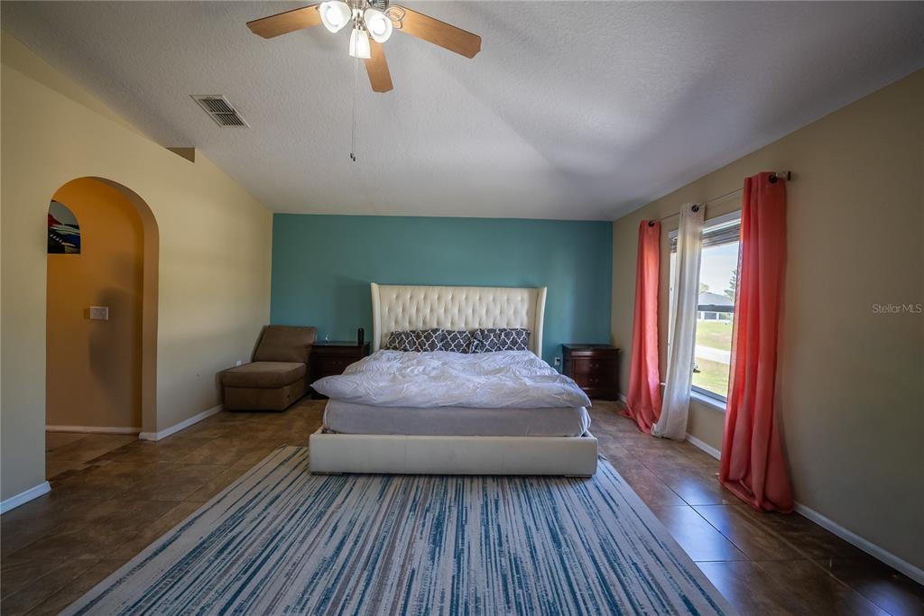 5306 Southwest 115th Street Road Ocala, FL 34476 - Photo 37 of 56 a bedroom with a bed and a chandelier