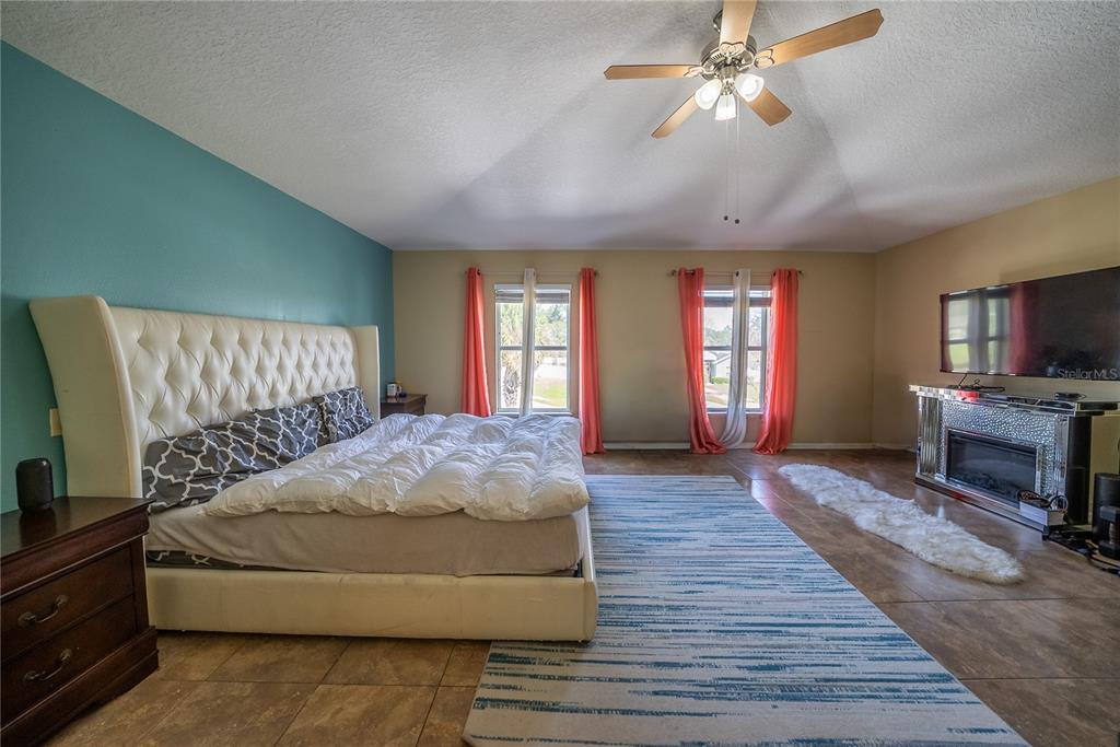 5306 Southwest 115th Street Road Ocala, FL 34476 - Photo 42 of 56 a spacious bedroom with a bed and a flat screen tv