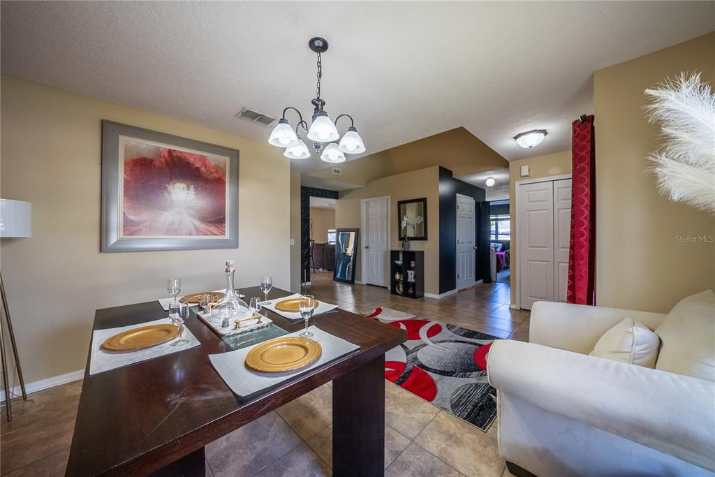 5306 Southwest 115th Street Road Ocala, FL 34476 - Photo 7 of 56 a living room with furniture and a chandelier