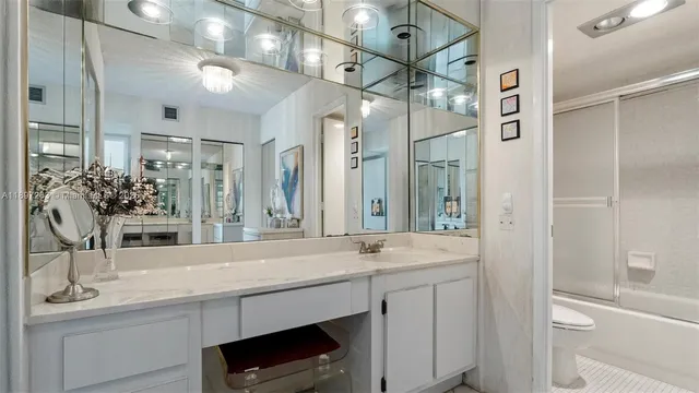 a bathroom with a granite countertop sink a toilet and a mirror