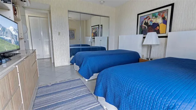 a bedroom with two beds and a flat screen tv