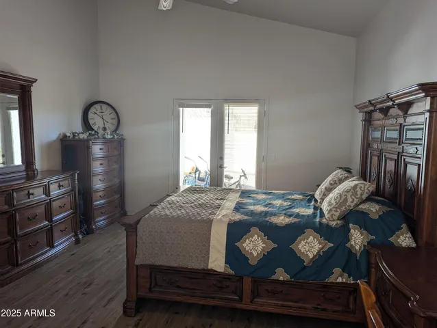 a bedroom with a bed next to a window with chair