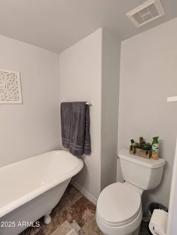 a white toilet sitting next to a bath tub