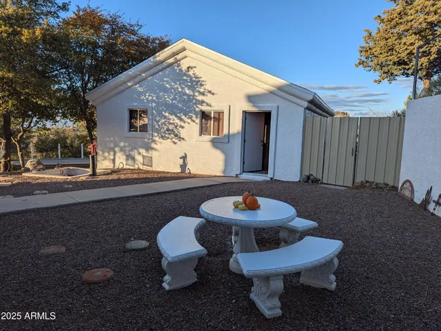 a view of a house with backyard fire pit and a large tree
