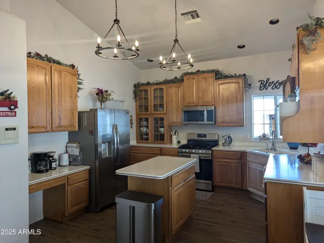 a kitchen that has a lot of cabinets and stainless steel appliances