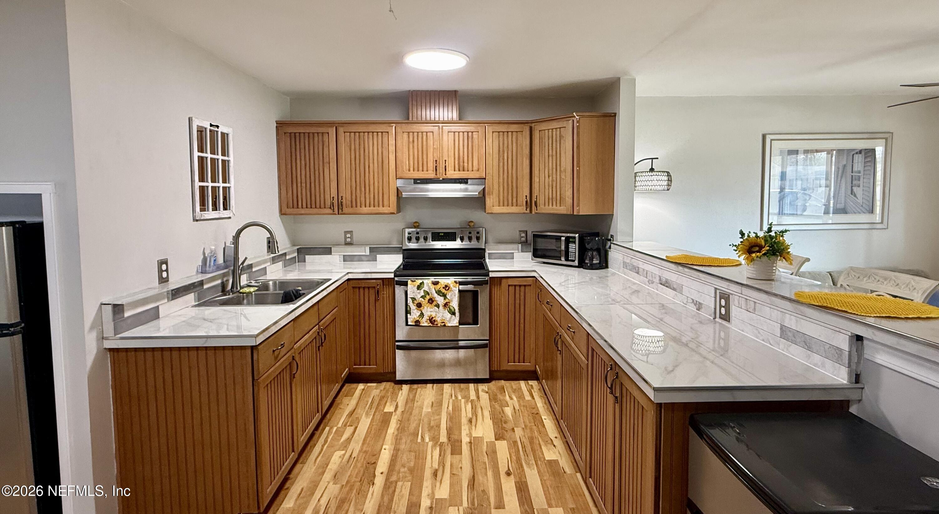 3173 Ricky Drive Jacksonville, FL 32223 - Photo 3 of 12 a kitchen with a sink stove top oven and cabinets
