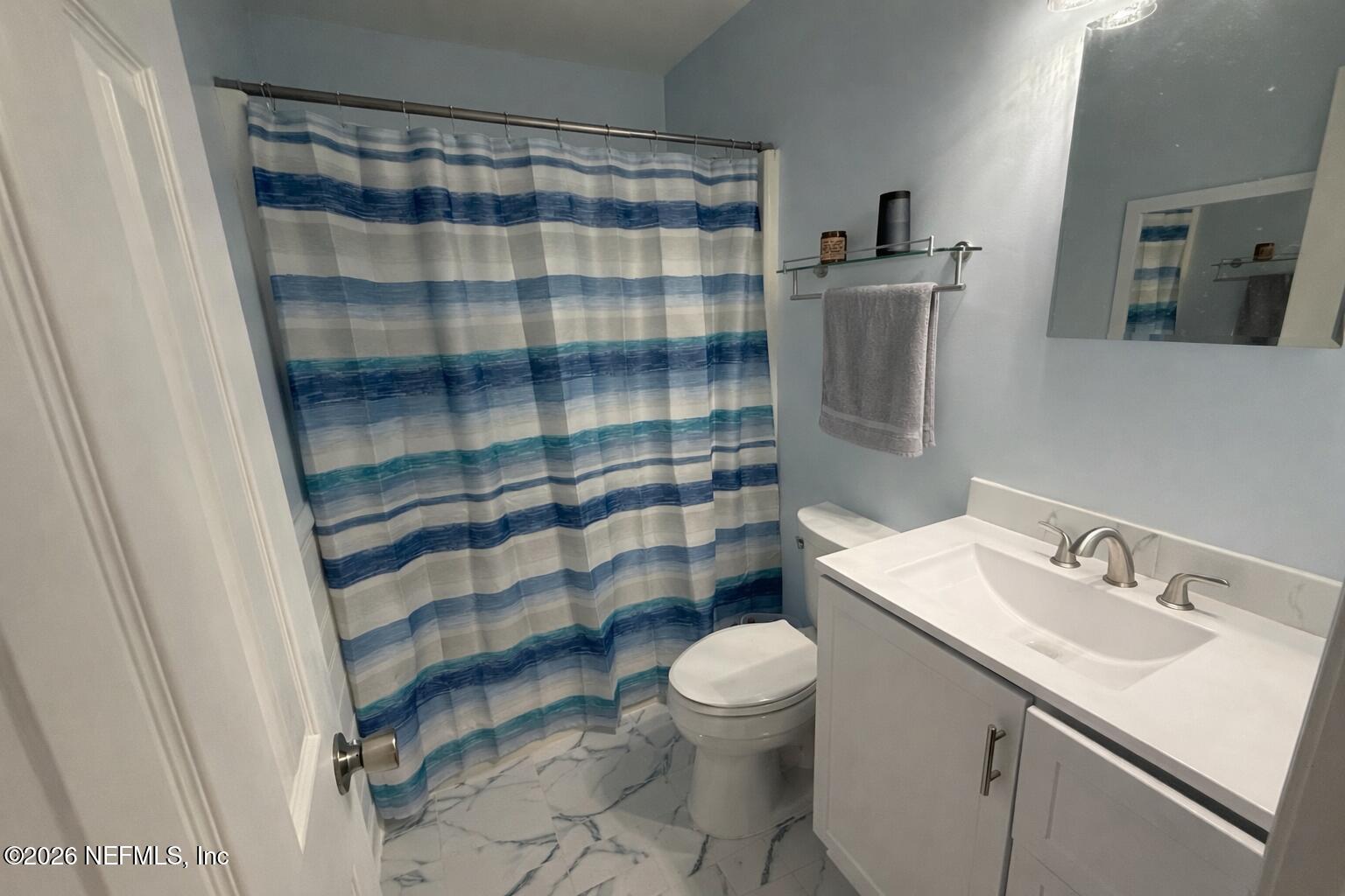 3173 Ricky Drive Jacksonville, FL 32223 - Photo 6 of 12 a bathroom with a sink a toilet a shower and a mirror