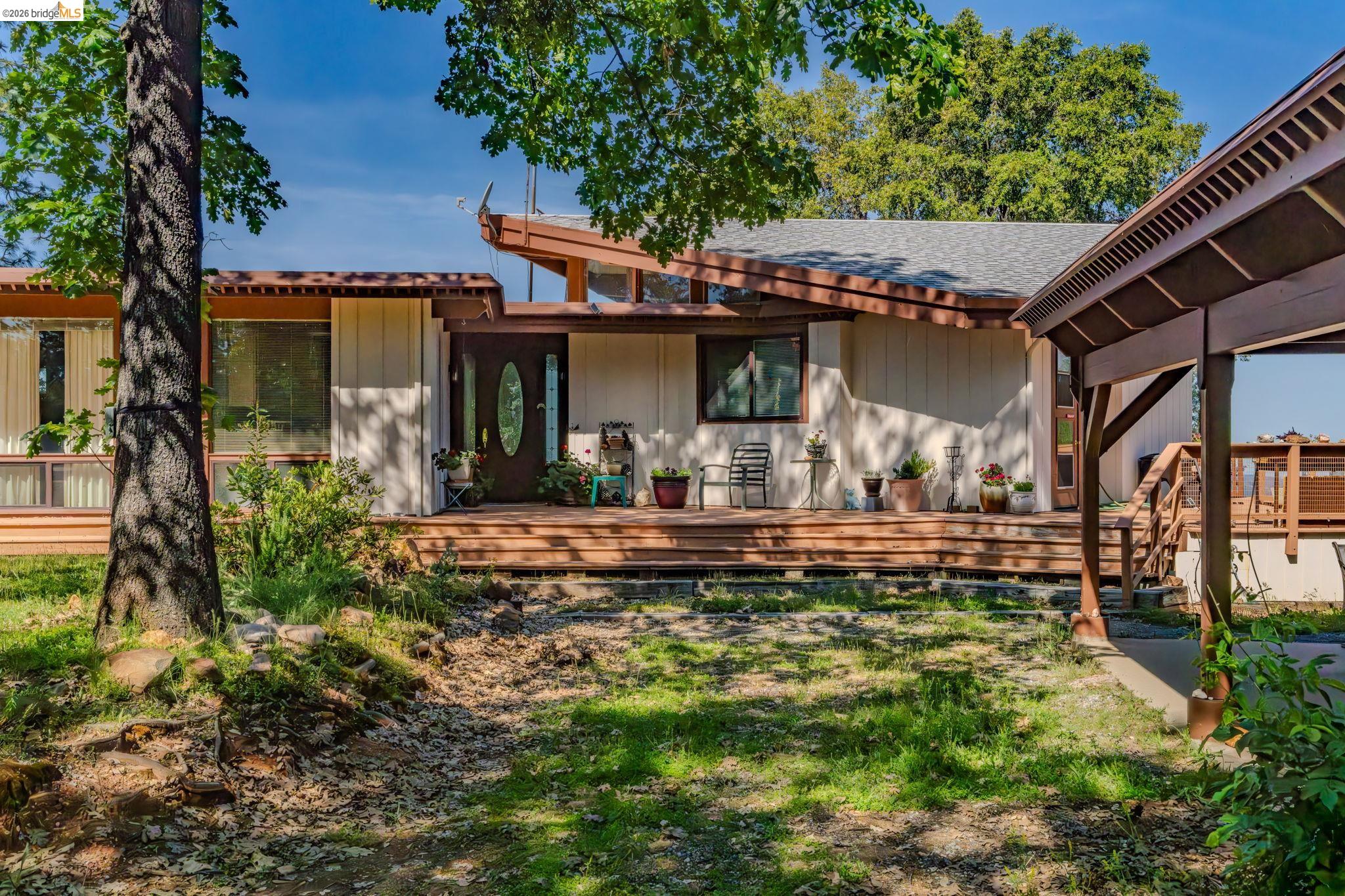 6161 Fullen Road Murphys, CA 95247 - Photo 4 of 53 a view of a patio with table and chairs potted plants and large tree