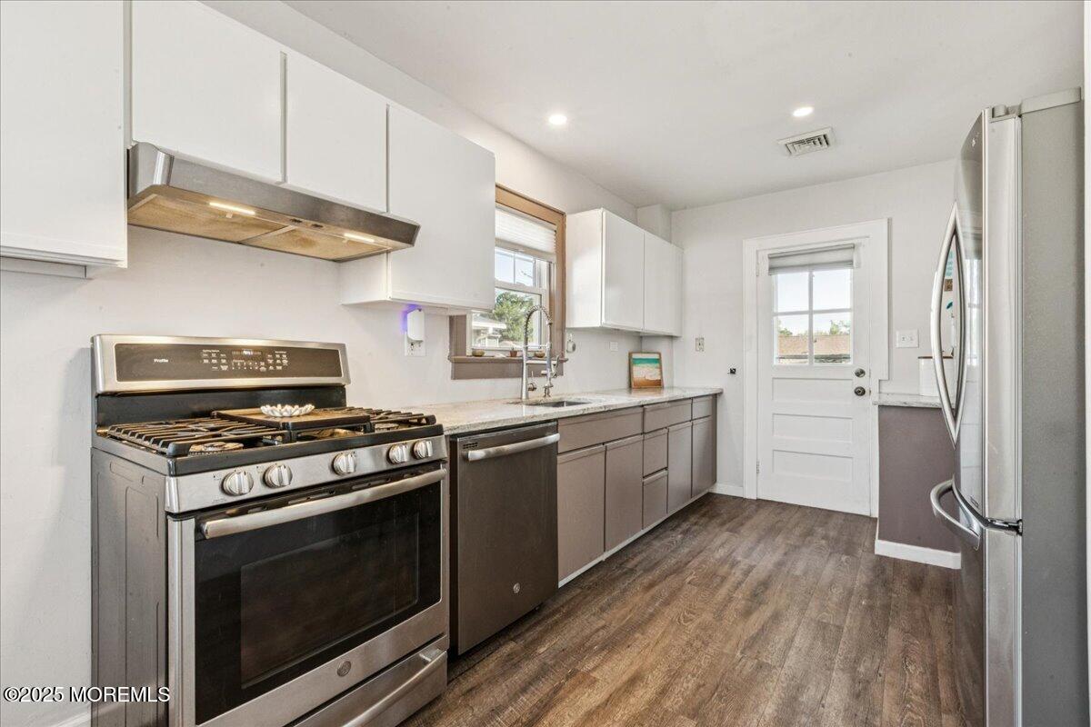 77 Drift Road Belford, NJ 07718 - Photo 10 of 23 a kitchen with granite countertop wooden floors and stainless steel appliances