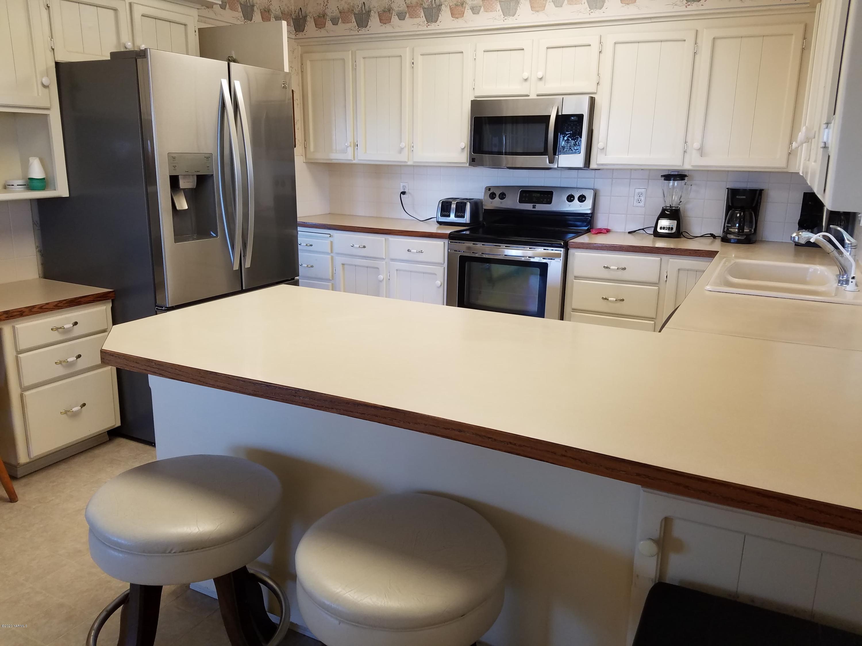 30 Wing Hill Road Grandview, WA 98930 - Photo 4 of 27 a kitchen with stainless steel appliances a refrigerator a stove a sink and a microwave