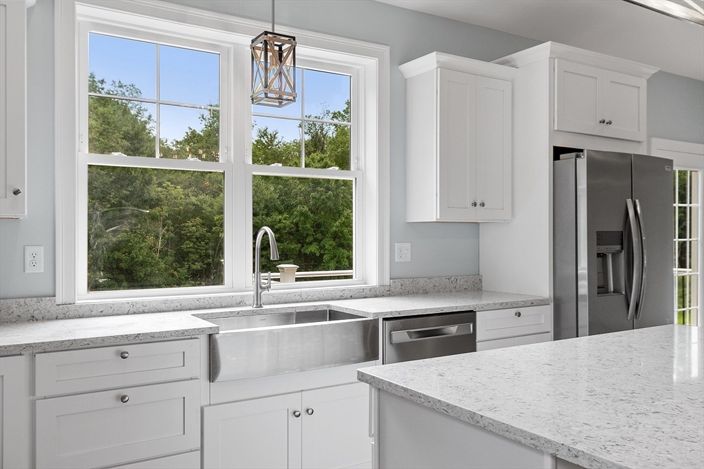 94 Fitchburg Road, Unit 2 Townsend, MA 01469 - Photo 6 of 31 a kitchen with granite countertop white cabinets and stainless steel appliances