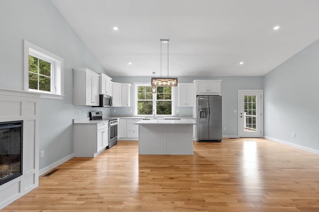 94 Fitchburg Road, Unit 2 Townsend, MA 01469 - Photo 10 of 31 a kitchen with stainless steel appliances granite countertop a refrigerator a sink dishwasher a oven with white cabinets and wooden floor