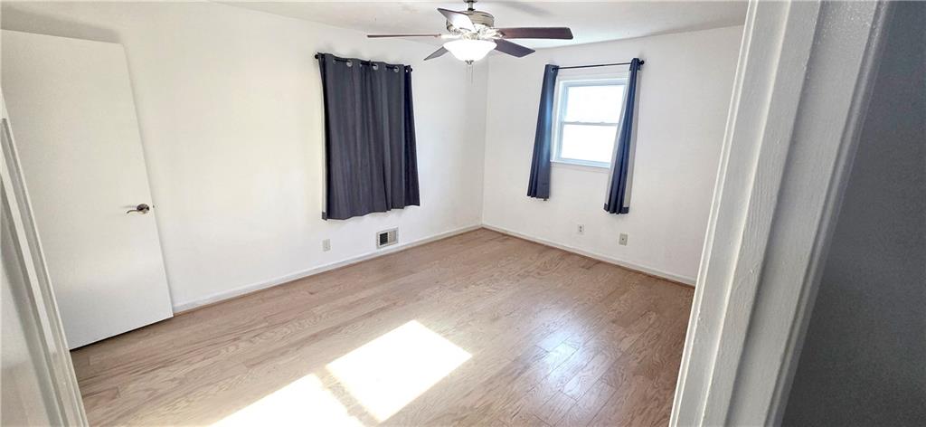 4034 Weeks Drive Kennesaw, GA 30144 - Photo 18 of 24 an empty room with wooden floor chandelier fan and windows