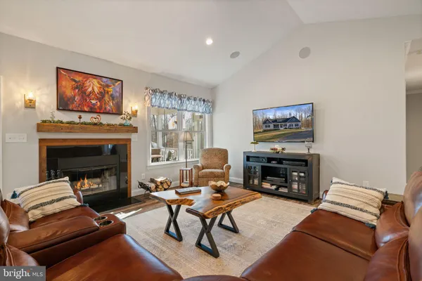 a living room with furniture fireplace and a large window