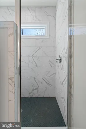 a bathroom with a granite countertop sink mirror and shower