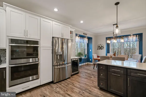 a kitchen with kitchen island granite countertop appliances cabinets and a sink