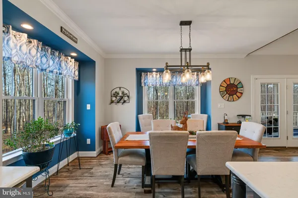 a dining room with furniture a chandelier and window