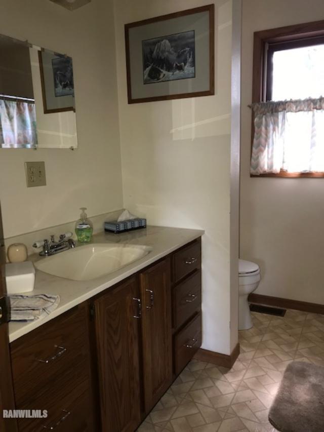 5808 Riverview Road Thomson, IL 61285 - Photo 5 of 9 a bathroom with a granite countertop sink a toilet and a window