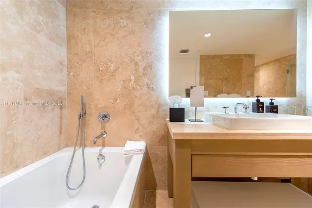 a bathroom with a granite countertop sink a mirror and a shower